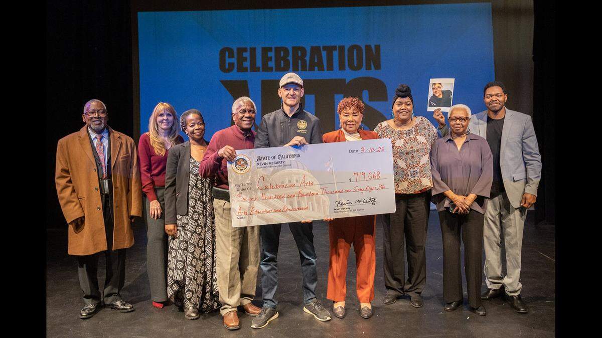 Assemblymember Kevin McCarty, middle, presents the Celebration Arts theater a check worth more than $700,000 in state grant money.