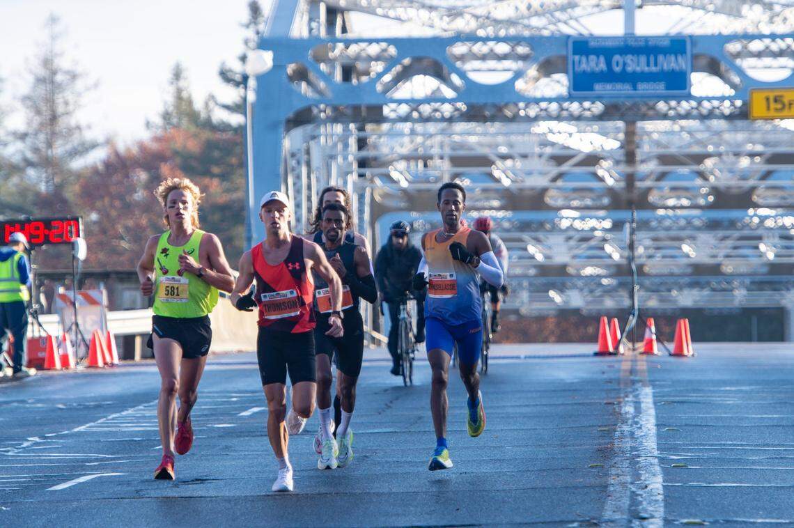 Futsum Zienasellassie, right, crosses the H Street Bridge on Sunday in the 2022 California International Marathon from Folsom to the state Capitol. Zienasellassie finished first overall.