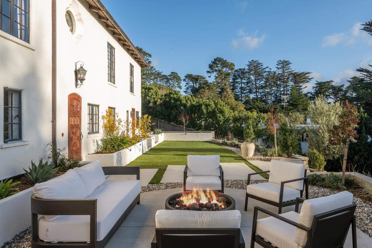 The outdoor space of the Carmel, California, home offers multiple sitting areas.