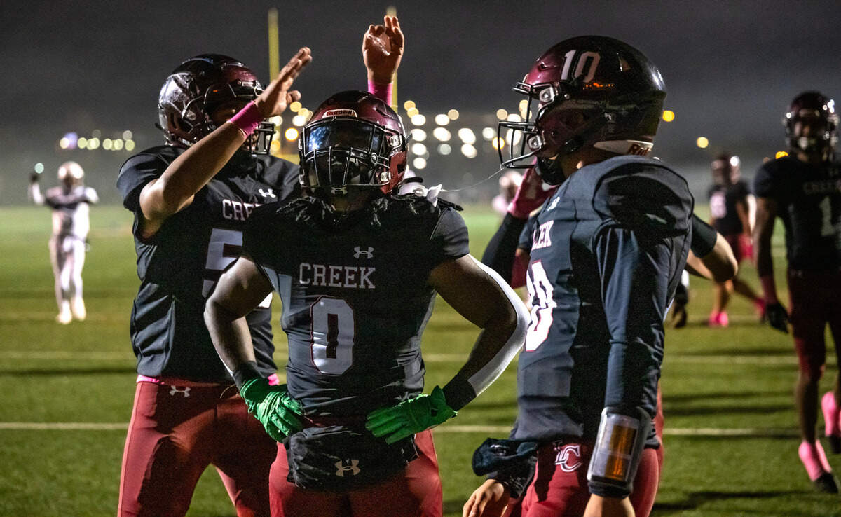 A stoic Laguna Creek Cardinals’ Armon Thorntona (0), center, is congratulated by teammates after a touchdown against Sheldon on Friday . Thorntona had six touchdowns on the night.