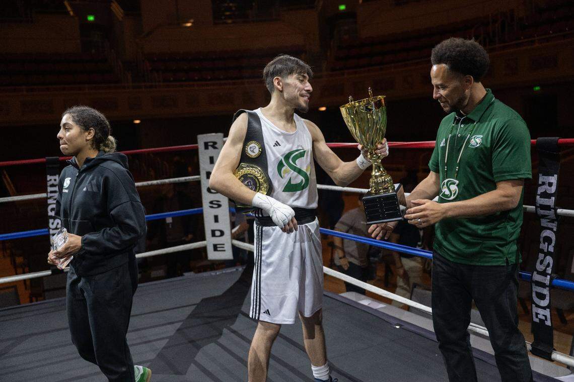 Sacramento State president Luke Wood receives the Causeway Boxing Classic trophy from Marcos Vasquez at Memorial Auditorium on Friday.