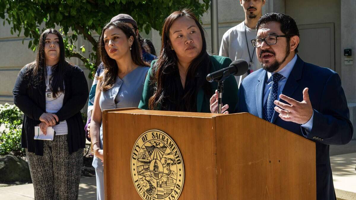 Sacramento City Councilmember Eric Guerra speaks during an April news conference at City Hall alongside council members Mai Vang, center, and Karina Talamantes, left, urging prompt council action to prohibit the use of city property for federal immigration enforcement.