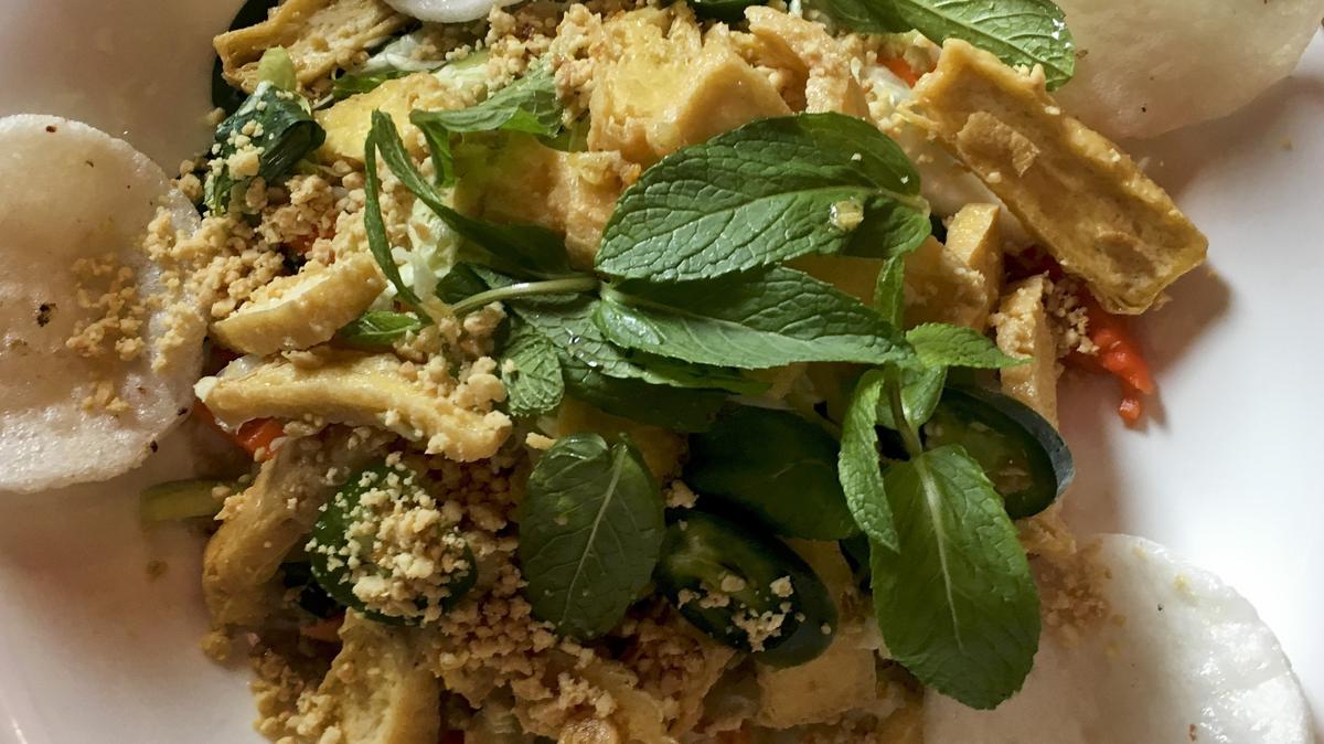 The tofu salad at Saigon Street Eat is a fresh standout and was hands down the best dish at Saigon Street Eat, a dramatic tangled mound of shredded cabbage, peanuts, fried shallots, jalapenos, tons of herbs—including the astringent note of rau ram—and slices of crunchy-edged but yielding fried tofu.