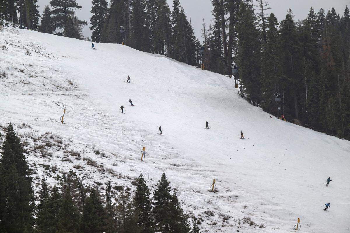 Skiers glide down a slope at Palisades Tahoe on Thursday, Dec. 21, 2023.
