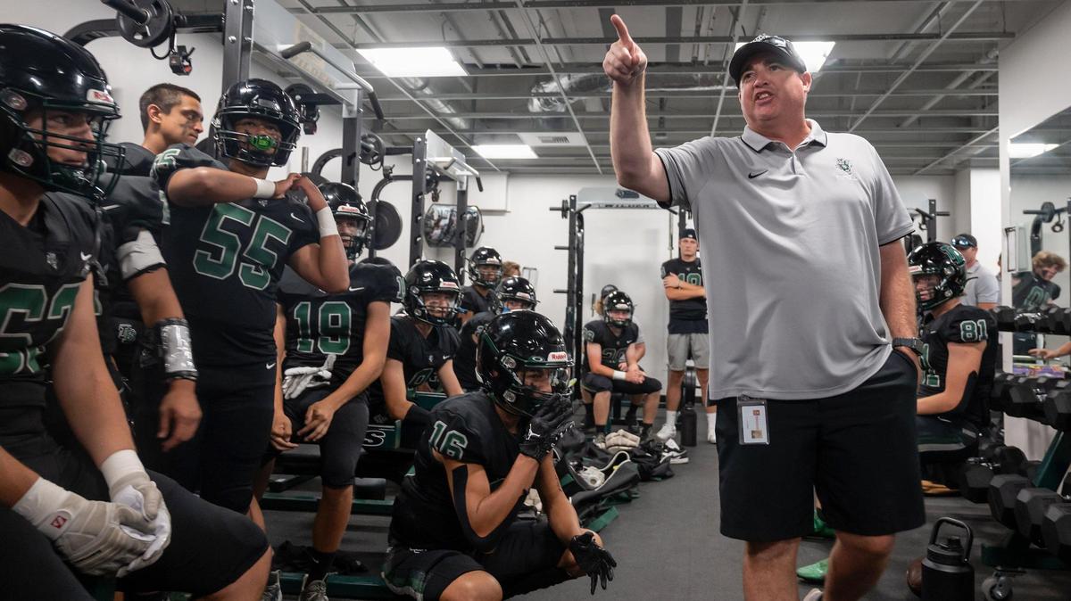 Twelve Bridges head coach Chris Bean talks to his team before its game against McClatchy in 2022. The Raging Rhinos defeated the Lions 36-35 in the school’s first varsity game.