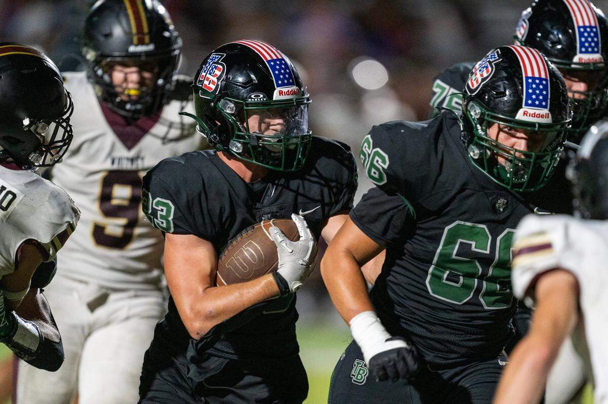Twelve Bridges Raging Rhinos running back Braeden Ward (23) follows blocker Raiden Podulka (66) to score a touchdown in the fourth quarter against the Whitney Wildcats on Sept. 6 at Twelve Bridges High School.