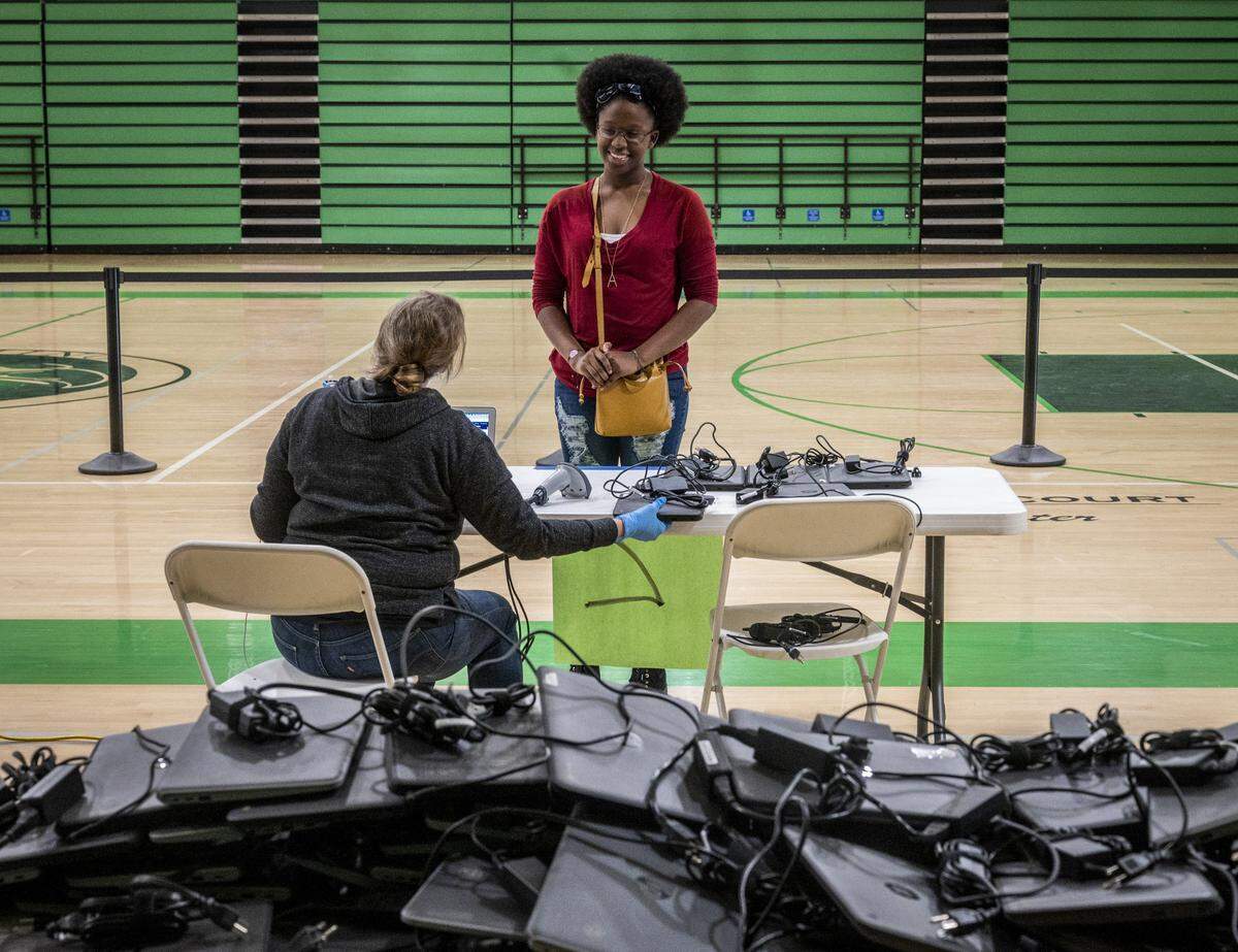 Sophomore Aniyah Simms smiles as she picks up a computer at El Camino Fundamental High School in Arden Arcade on Monday, March 30, 2020. The San Juan Unified School District is distributing Google Chromebooks for distance learning as schools are closed because of the coronavirus.