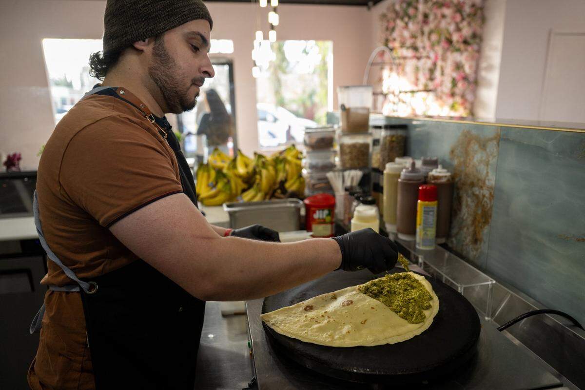 Az Alqahtani prepares a Dubai chocolate crepe at Nour’s Cafe on Thursday, Feb. 20, 2025, in Carmichael.