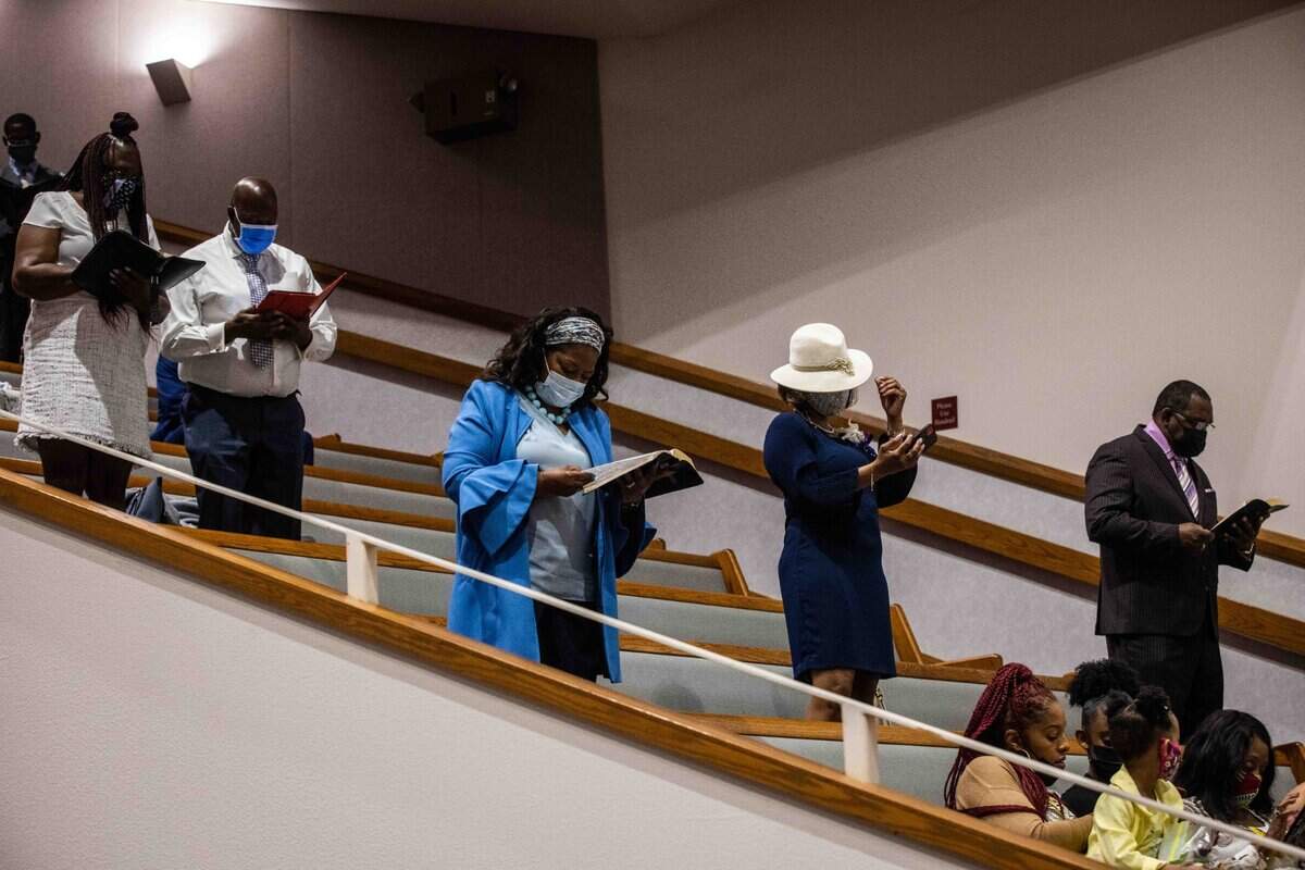 Congregants stand while reading scripture at St. Paul Missionary Baptist Church.