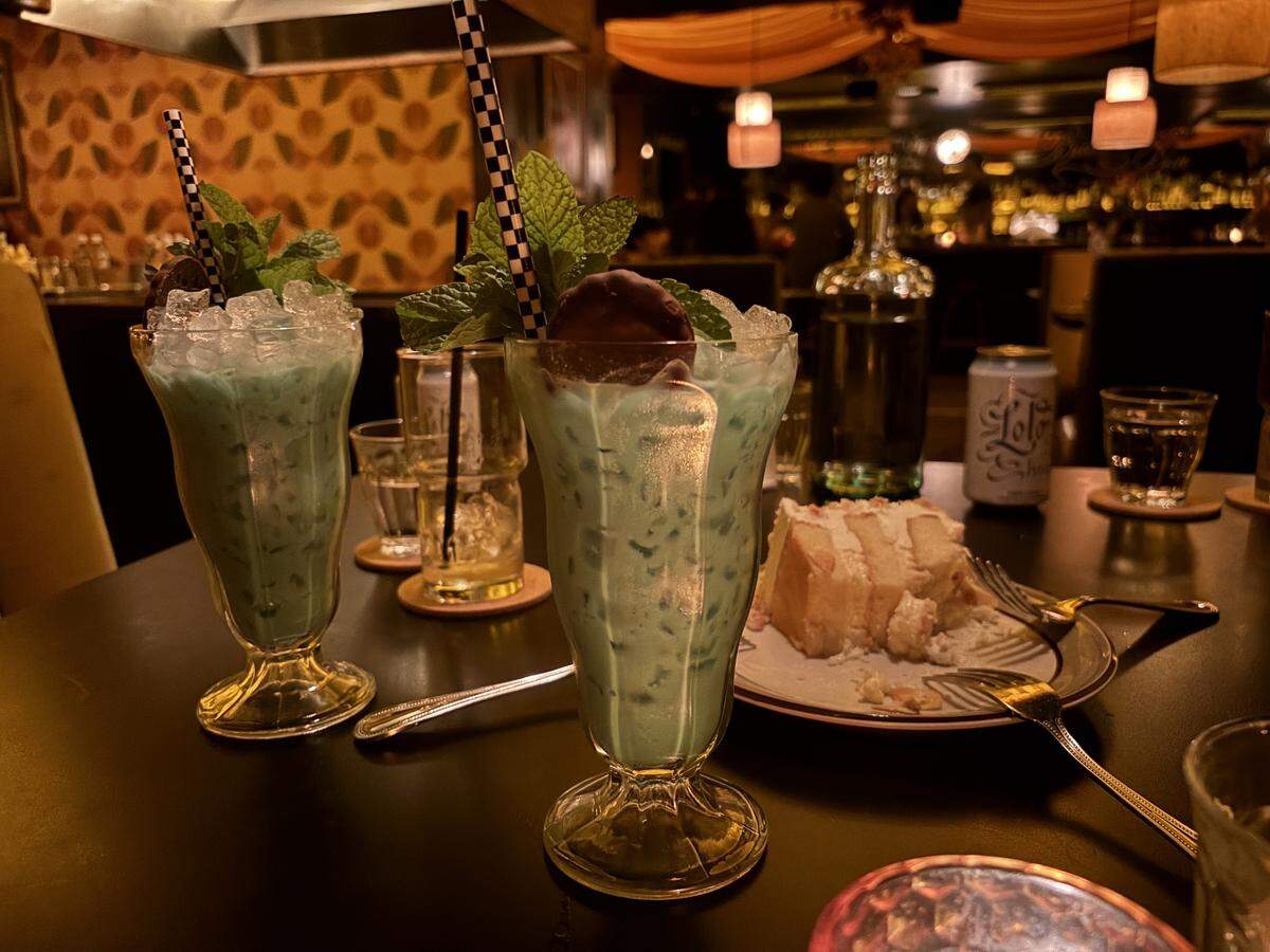 The Butterscotch Den serves a decadent post-meal boozy grasshopper cocktail, made with softened vanilla ice cream, Cynar amaro and cremes de menthe and cacao, garnished with sprigs of mint and a Thin Mint cookie.