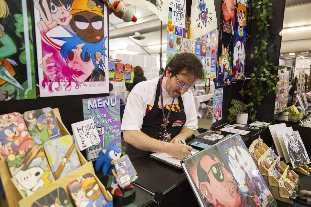 Sacramento artist James Plummer draws in his booth during SacAnime at Cal Expo on Friday.