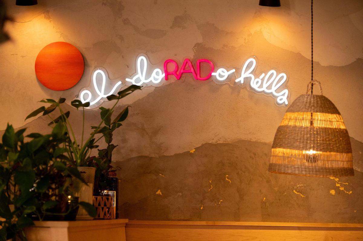 A neon El Dorado Hills sign sits above tables at the Almighty Food Co. in El Dorado Hills.