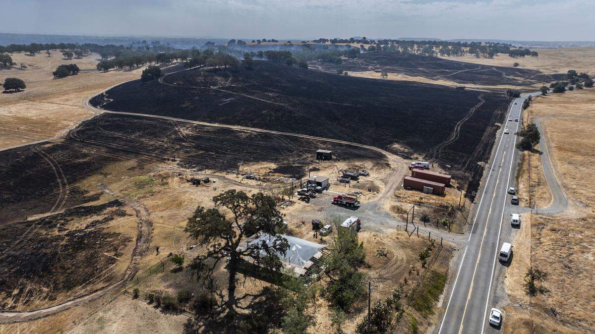 Burned grasslands surround a home on Ione Road that was protected by firefighters during the Brown Fire near Rancho Murieta on Tuesday.
