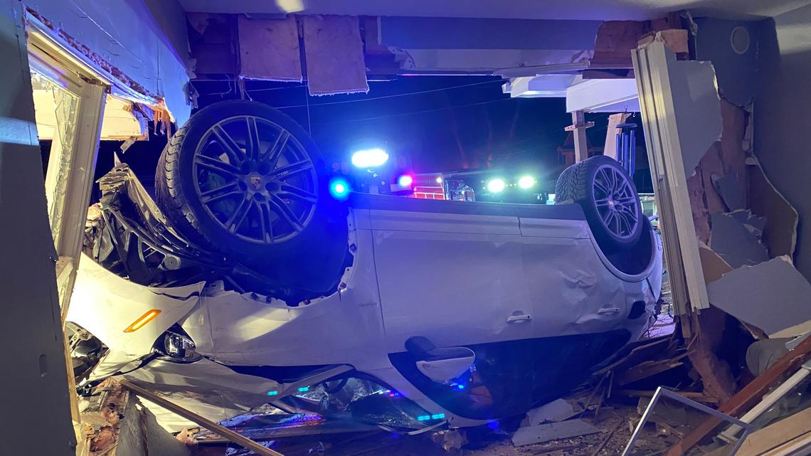 A Porsche SUV landed upside down in a Colorado home, police said. The driver was charged and booked into jail.