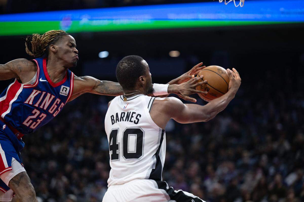 Sacramento Kings guard Keon Ellis (23) defends San Antonio Spurs forward Harrison Barnes (40) on the defensive end in the first half on Sunday. It was Barnes’ first appearance at at Golden 1 Center since being traded to the Spurs. 