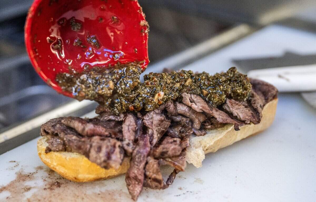 A steak sandwich is topped off with chimichurri sauce at the Buenos Aires Grill food truck on Friday, Feb. 7, 2025, in Auburn.