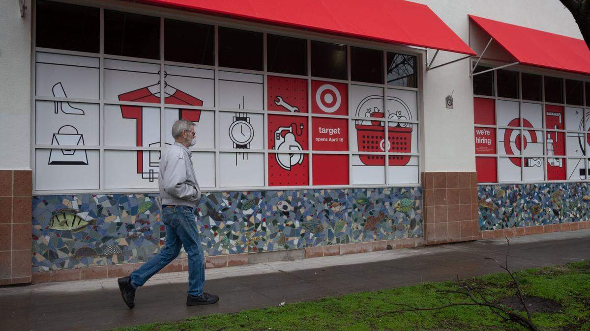 A masked man walks past the announced location of a Target store at the intersection of 17th and J streets in midtown Sacramento on Tuesday, Feb. 2, 2021. The store is projected to open on April 15th.