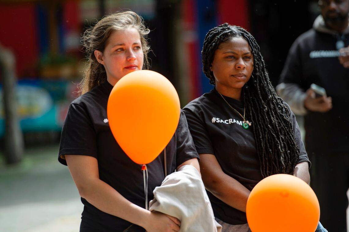 Teachers at Capitol Collegiate Academy Rachel La Due, left, and Aaron Allen listen to the speakers during the march for Communities Against Gun Violence at Ali Youssefi Square on Sunday in downtown Sacramento.