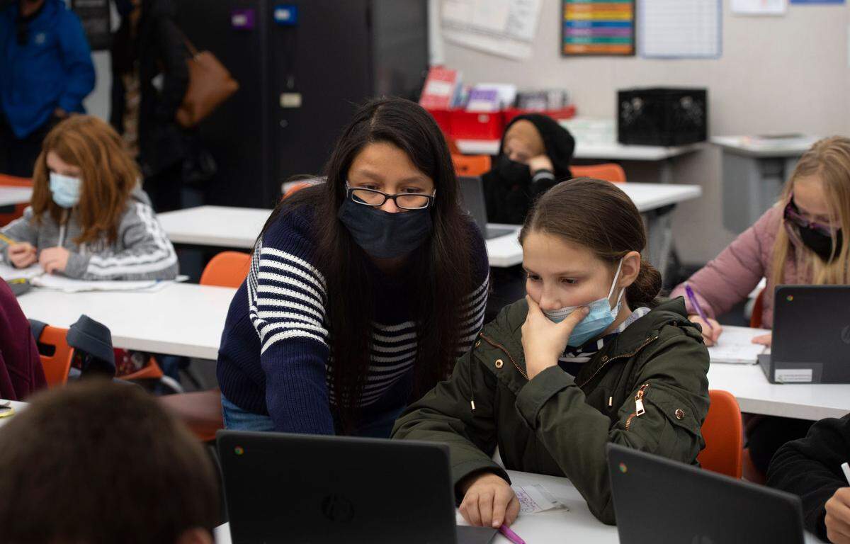 Substitute teacher Laura Jimenez, left, helps Yuliia Tkach, 12, a sixth-grader at Sylvan Middle School in Citrus Heights on Thursday, Dec. 9, 2021. Like many local school districts, San Juan Unified has a number of teaching positions unfilled.