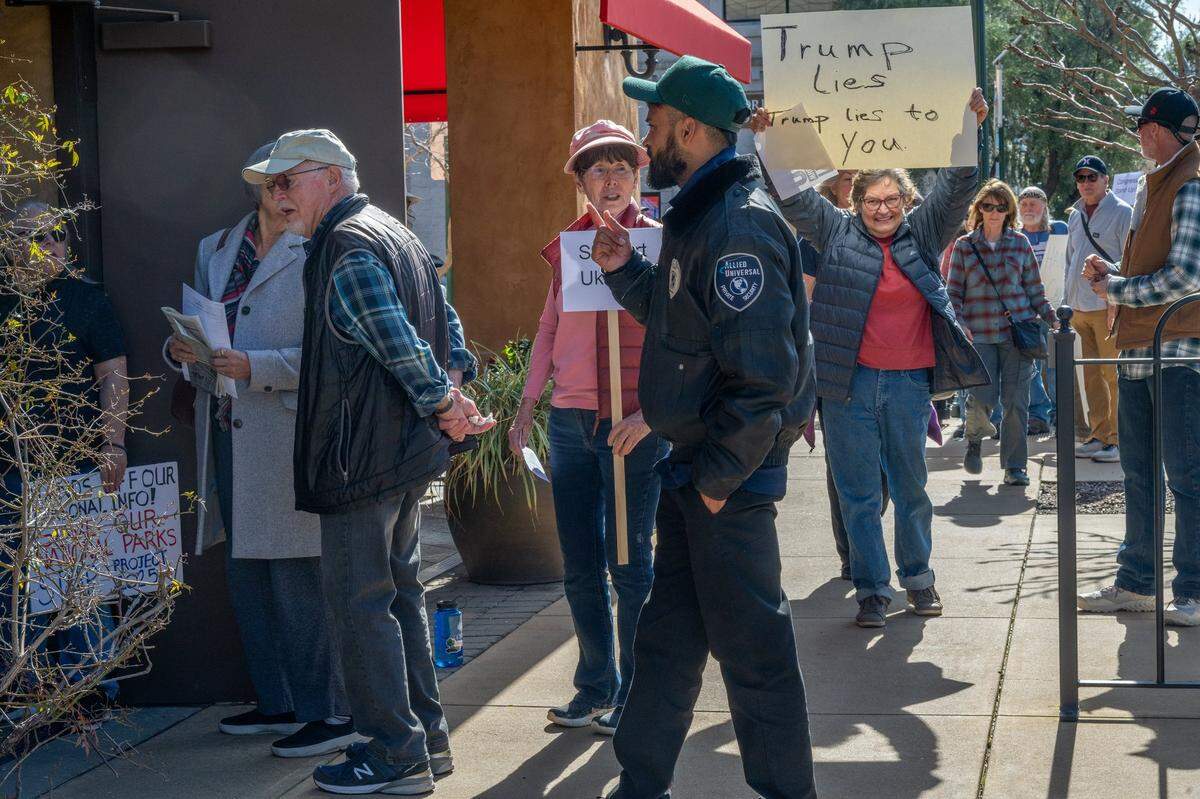 Placerville resident Rebecca Guinn, right, holds a sign that says “Trump lies to you” near Congressman Tom McClintock’s office in El Dorado Hills Town Center on Friday as a security guard warns the group that they can’t protest on private property. Groups of seven were allowed into McClintock’s office but he was not there.