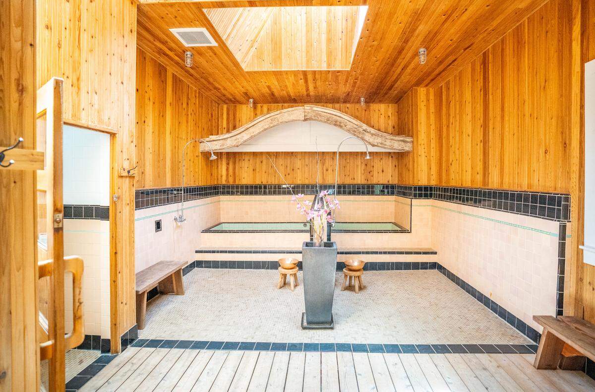 The bathhouse area of the Miyazaki Bathhouse is a large, open room with cedar walls and natural illumination from two skylights.