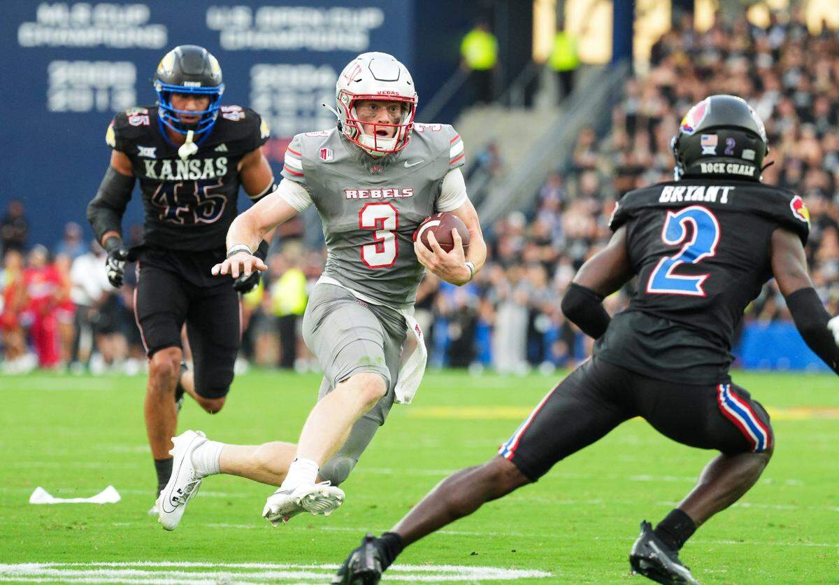 UNLV Rebels quarterback Matthew Sluka (3) runs the ball against Kansas Jayhawks defensive end Dean Miller (45) and cornerback Cobee Bryant (2) during the first half at Children’s Mercy Park.