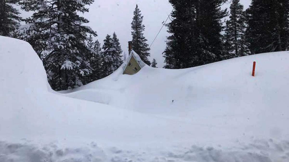 Snow covers a building in the Donner Pass area of California in 2019. On Saturday, a snowmobiler plunged 900 feet to his death after walking on an overhanging cornice on nearby Frog Lake Cliffs.