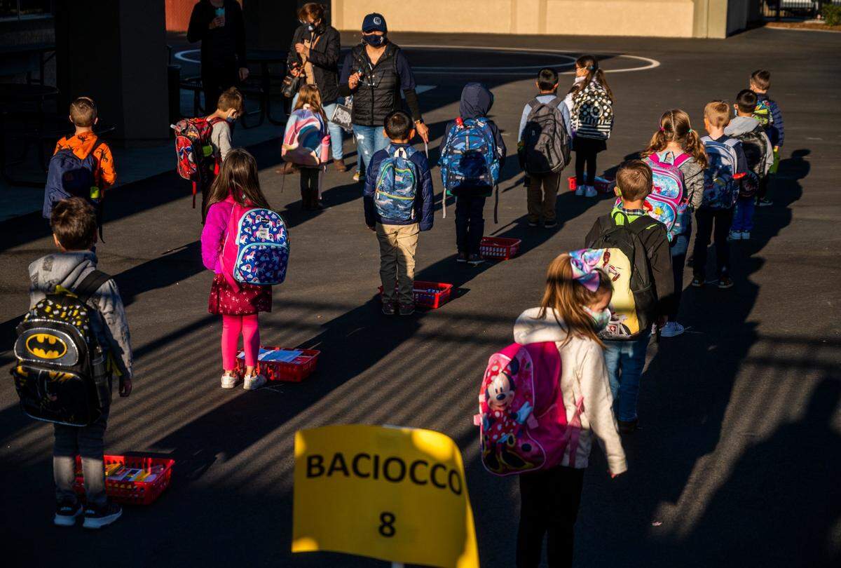School children wait in socially distanced lines before they start their first day of in-class instruction at Folsom Hills Elementary School on Thursday, Nov. 12, 2020.