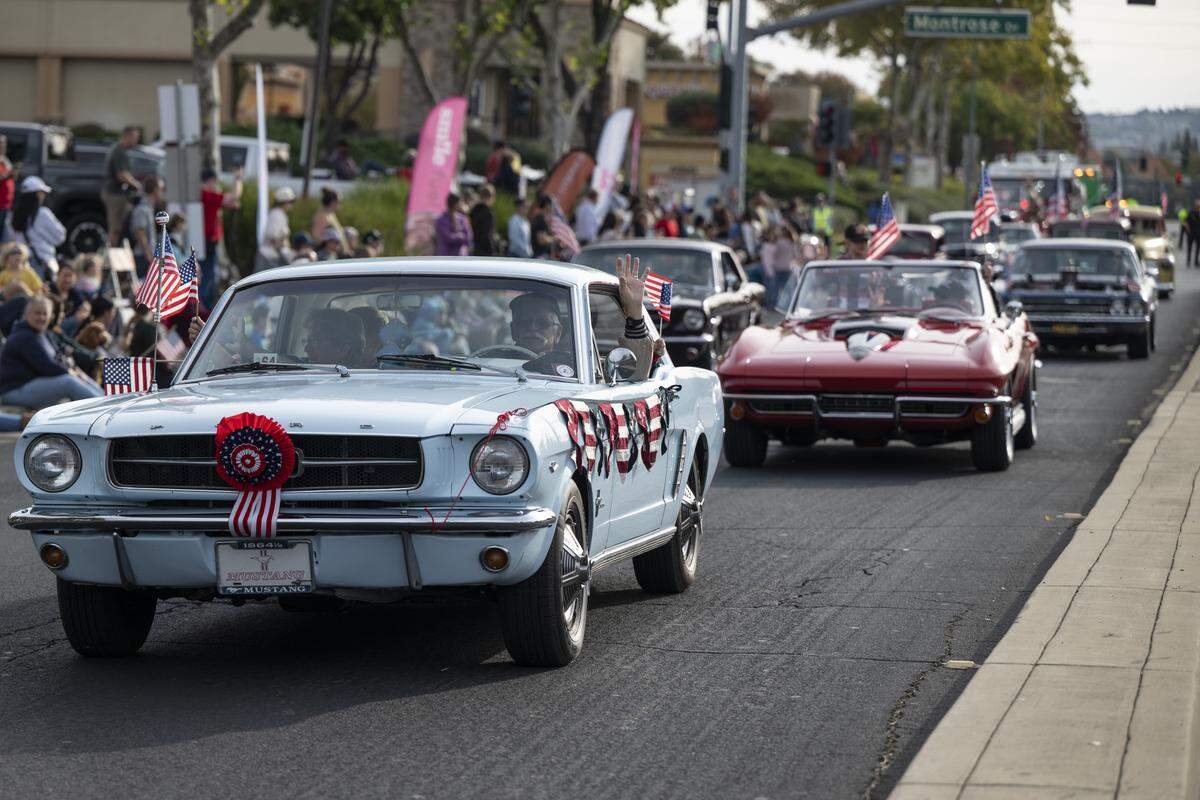Vintage cars are driven down East Bidwell Street during a Veterans Day parade in Folsom on Tuesday, Nov. 11, 2025.