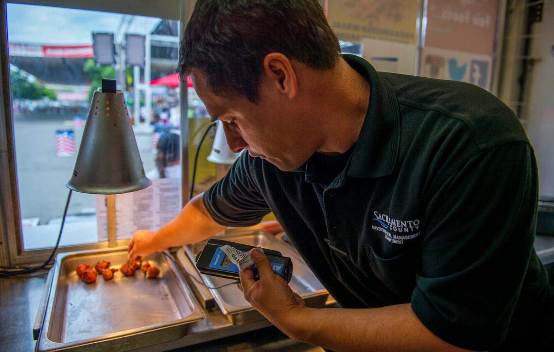 Steve LePage, an environmental health specialist with the Sacramento County Environmental Management Department, demonstrates the procedures of a health inspection at the California State Fair at Cal Expo on Friday.