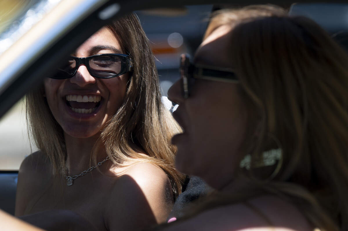 Yazlyn, left, laughs, as she chats with Mayra of the Lady Lowriders car club in Mayra’s lowrider, Ms. Champagne, during the fourth annual Lowrider Holiday Celebration in Sacramento on Sunday, June 21, 2026.