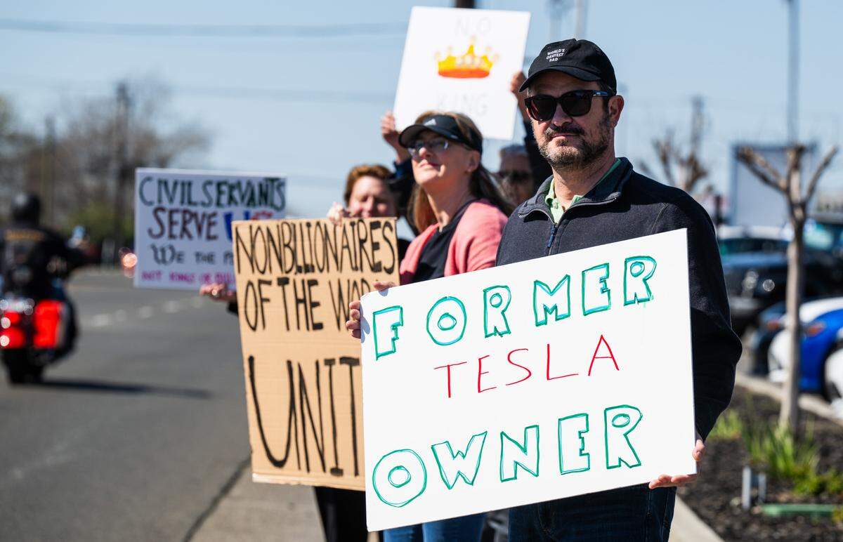 A former Tesla owner who wouldn’t give his name demonstrates against Elon Musk at a Tesla dealership on Arden Way near Sacramento on Saturday, March 8, 2025. More than 100 people lined both sides of street to protest the role of the tech billionaire and Tesla CEO in the Trump administration.