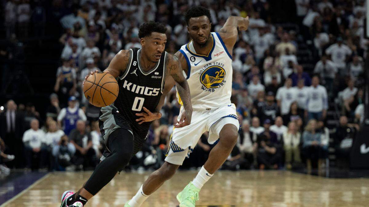 Sacramento Kings guard Malik Monk (0) drives past Golden State Warriors forward Andrew Wiggins (22) during Game 1 at Golden 1 Center on Saturday. Wiggins is questionable for Game 3 on Thursday.