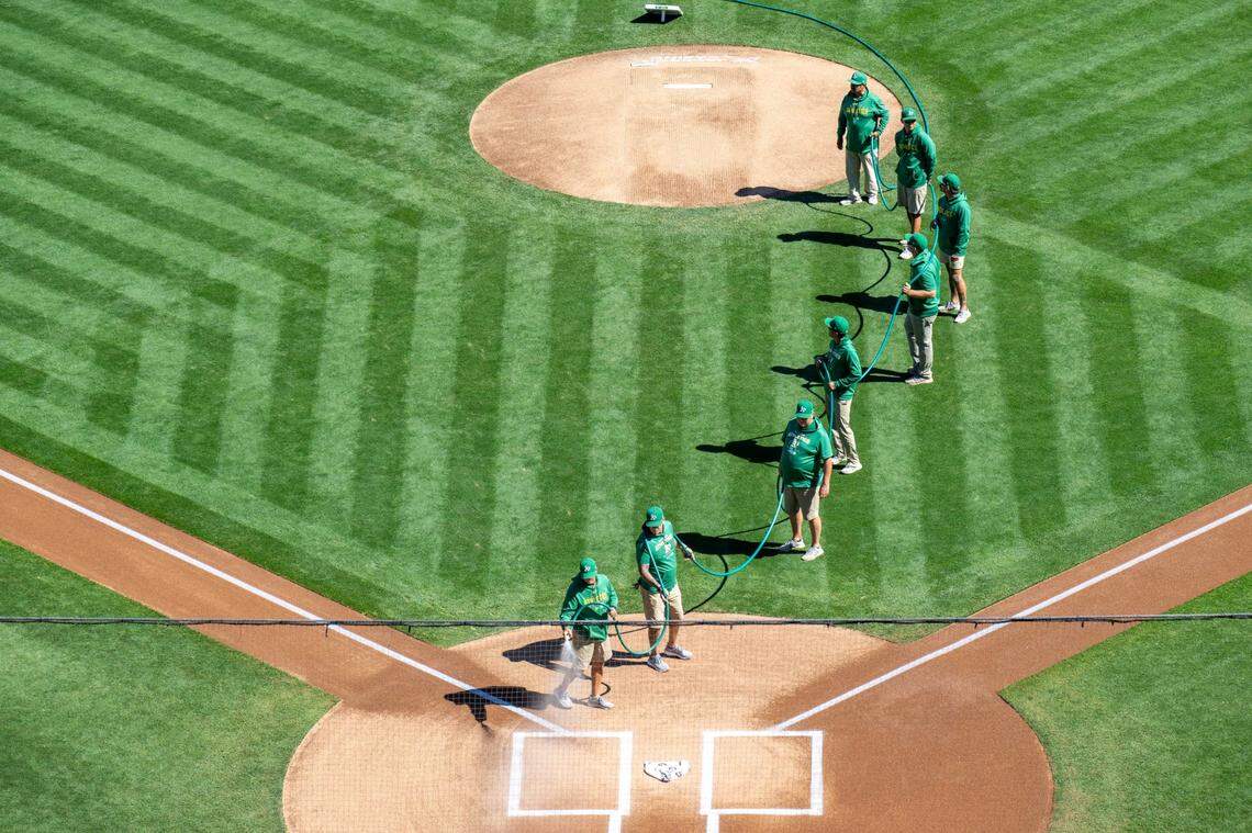 Groundskeepers water the field before the Oakland A’s play the Texas Rangers in the final home game at Oakland-Alameda County Coliseum on Thursday.