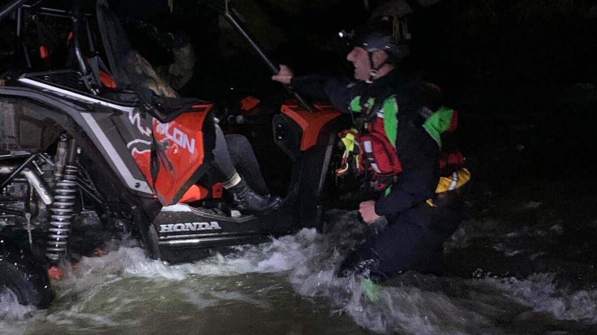 Cal Fire personnel pull a woman from Wolf Creek in Nevada County on Saturday, Feb. 13, 2021.