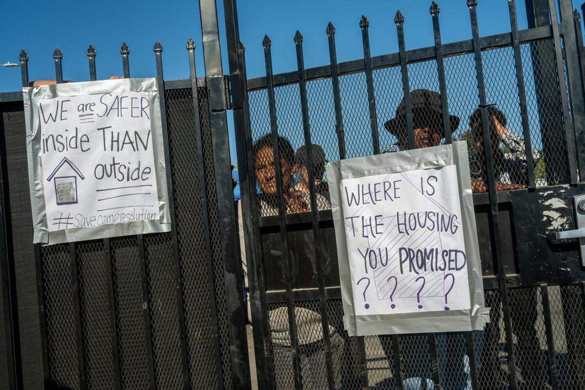 Residents of Camp Resolution homeless encampment wait by the gate for the Sacramento fire marshal to reinspect Camp Resolution on Friday. They said they had been working all night to address the fire department’s concerns.