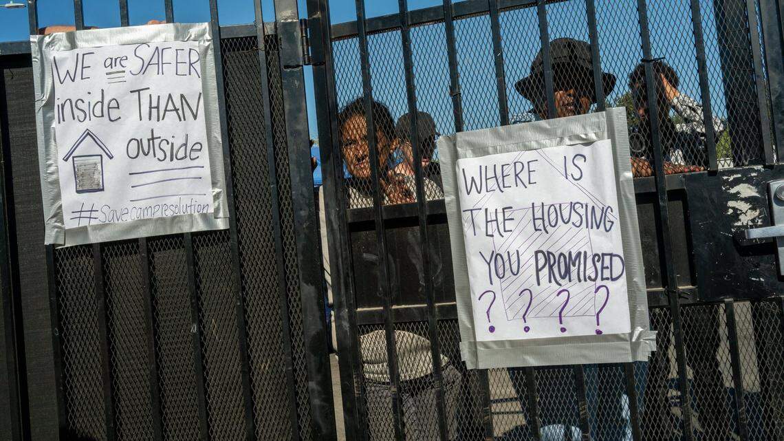 Residents of Camp Resolution homeless encampment wait by the gate before a fire inspection on Aug. 9. They said they had been working all night to address the fire department’s concerns.