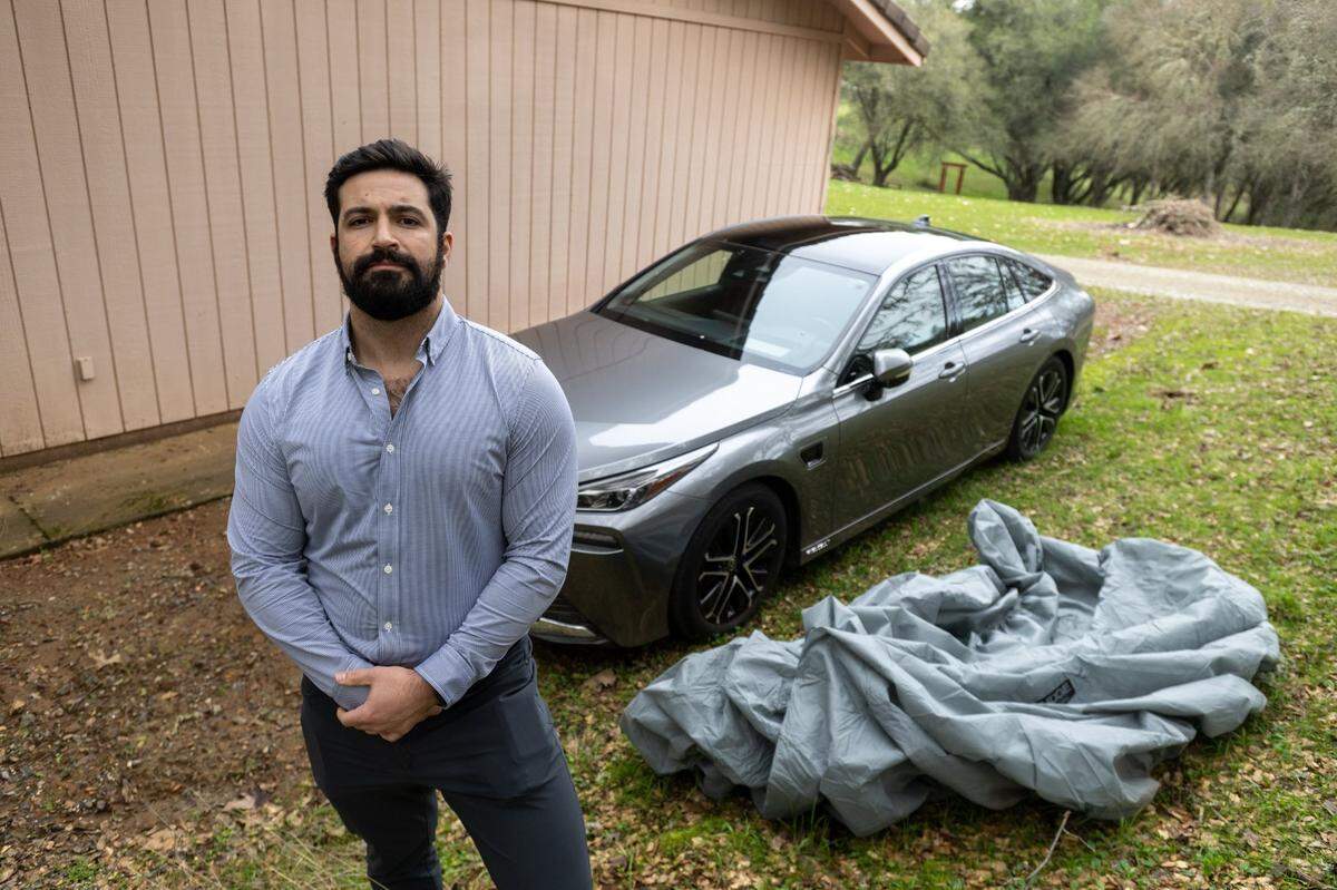 Natomas resident Sam D’Anna stands next to his $75,000 Toyota Mirai hydrogen car last month. He is still paying $1,100 a month for the vehicle, which he keeps under a tarp at his father’s house in Rescue.