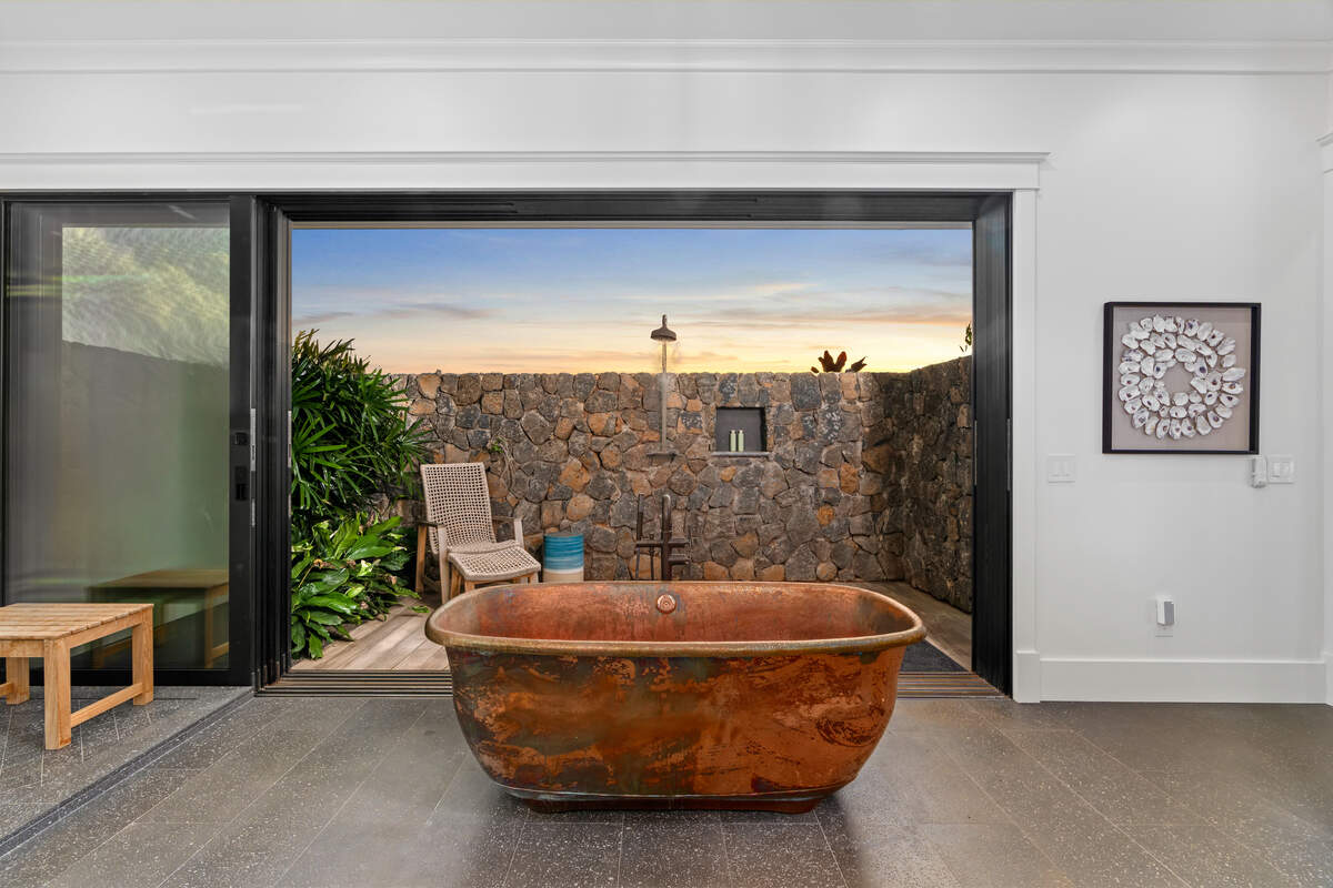 The primary suite is a private sanctuary with a spa-like bath, complete with a hand-hammered copper tub and verdant indoor-outdoor garden shower