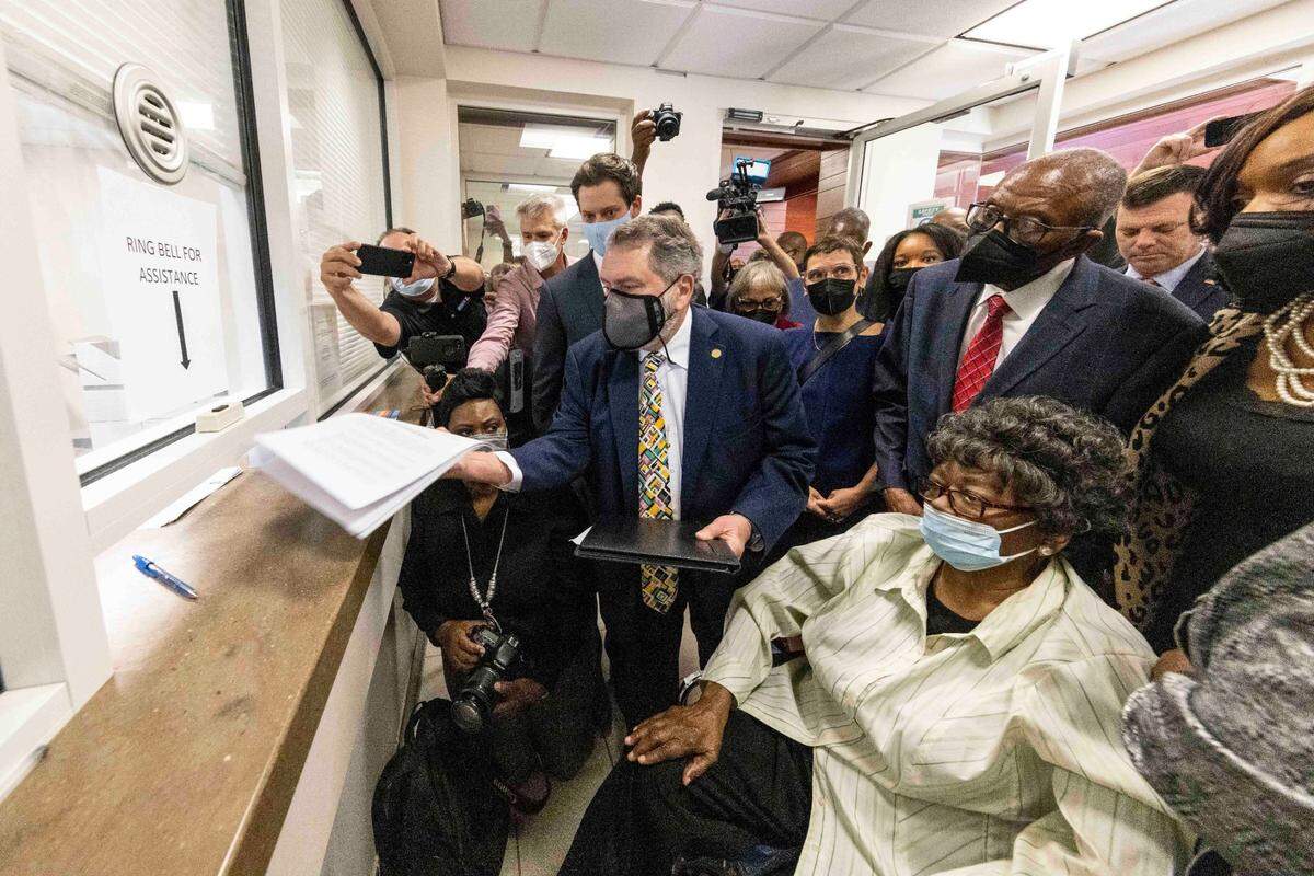 Claudette Colvin, seated, watches as her attorney Gar Blume files paperwork in juvenile court to have her juvenile record expunged, Tuesday, Oct. 26, 2021, in Montgomery, Ala. Colvin was arrested for not giving up her seat on a bus in 1955. Behind Colvin wearing a red tie is Fred Gray, her original attorney from the civil rights era. (AP Photo/Vasha Hunt)