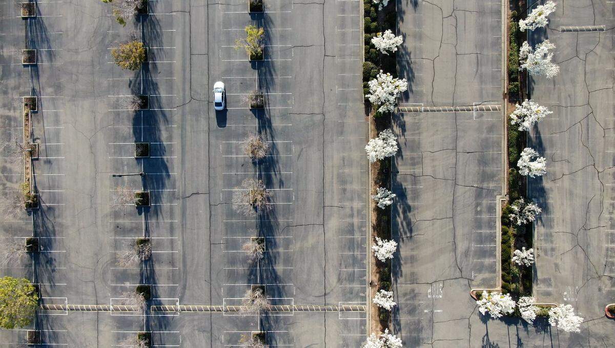 A car drives through one of many empty parking lots at offices left largely empty off Zinfandel Drive on Thursday in Rancho Cordova. A combination of remote working and the coronavirus pandemic has altered much of the local economy.