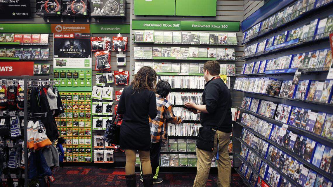 An employee assists customers shopping for Microsoft Xbox 360 video games inside a GameStop Corp. store in Louisville, Ky., on March 15, 2018. In June 2018, the company confirmed reports that its in talks with third parties for a potential buyout.