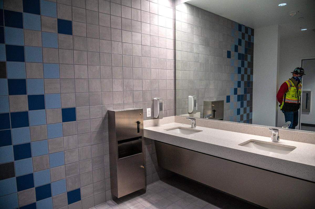 Heerhartz is reflected in the mirror of the men’s bathroom where tiles form a water design on the walls and floor on the third floor.