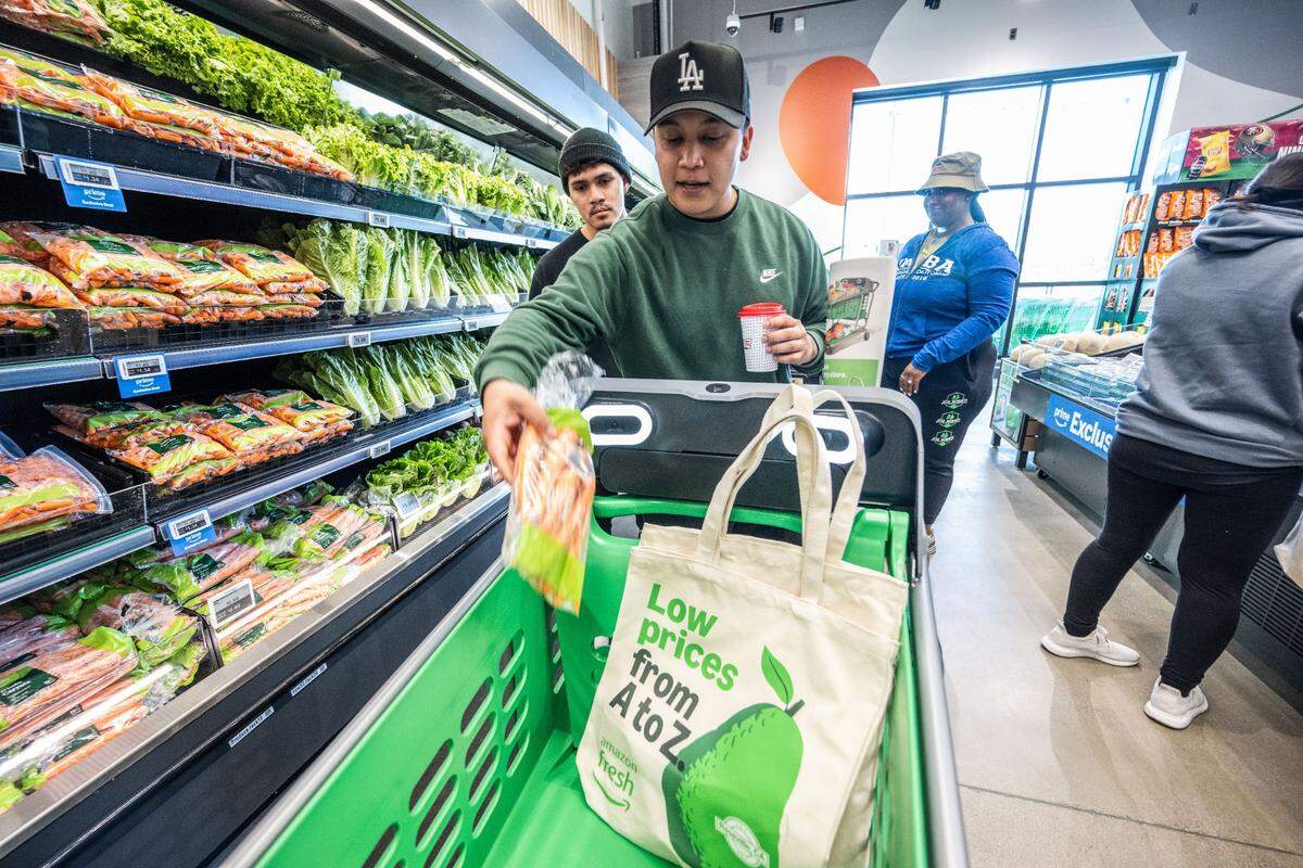 Isaiah Ramirez of Roseville loads a bag of carrots onto his Dash Cart on Thursday during the grand opening of Amazon Fresh in Roseville, the chain’s first location in Northern California. The cart has cameras, a scale to weigh produce and other items, and a bar code scanner that automatically adds the items to the Amazon app.
