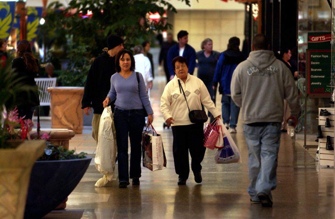 Cyndi Padilla and her mother Vera Ruiz carry bags of gifts as the two try to get their holiday shopping done inside Sunrise Mall in December 2004.