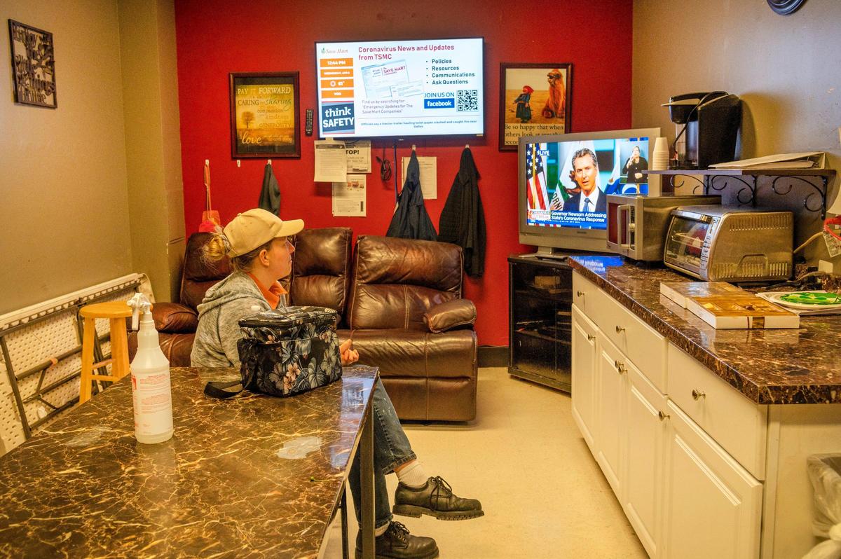 Erin Fox, a multi purpose clerk who works mostly in the butcher block area at Save Mart, practices social distancing in the break room a while watching Governor Gavin Newsom during a coronavirus press conference, Wednesday, April 8, 2020. “I was hoping he would announce this was over and we could all go back to normal,” she said. “Even our employees practice social distancing on break sitting six feet apart,” said Victoria Castro, communications director for Save Mart.