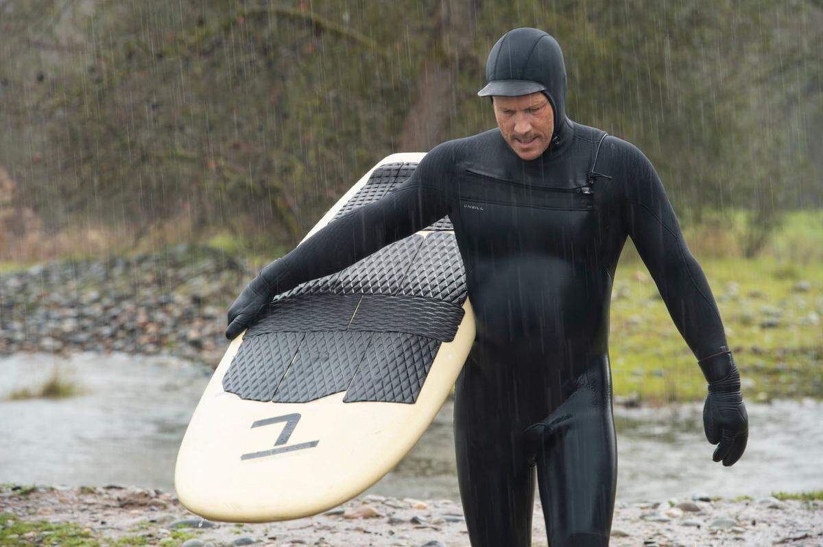 Mark Divittorio makes his way back to the water to river surf in rain starts on Sunday, March 12, 2023, at the American River near Carmichael.