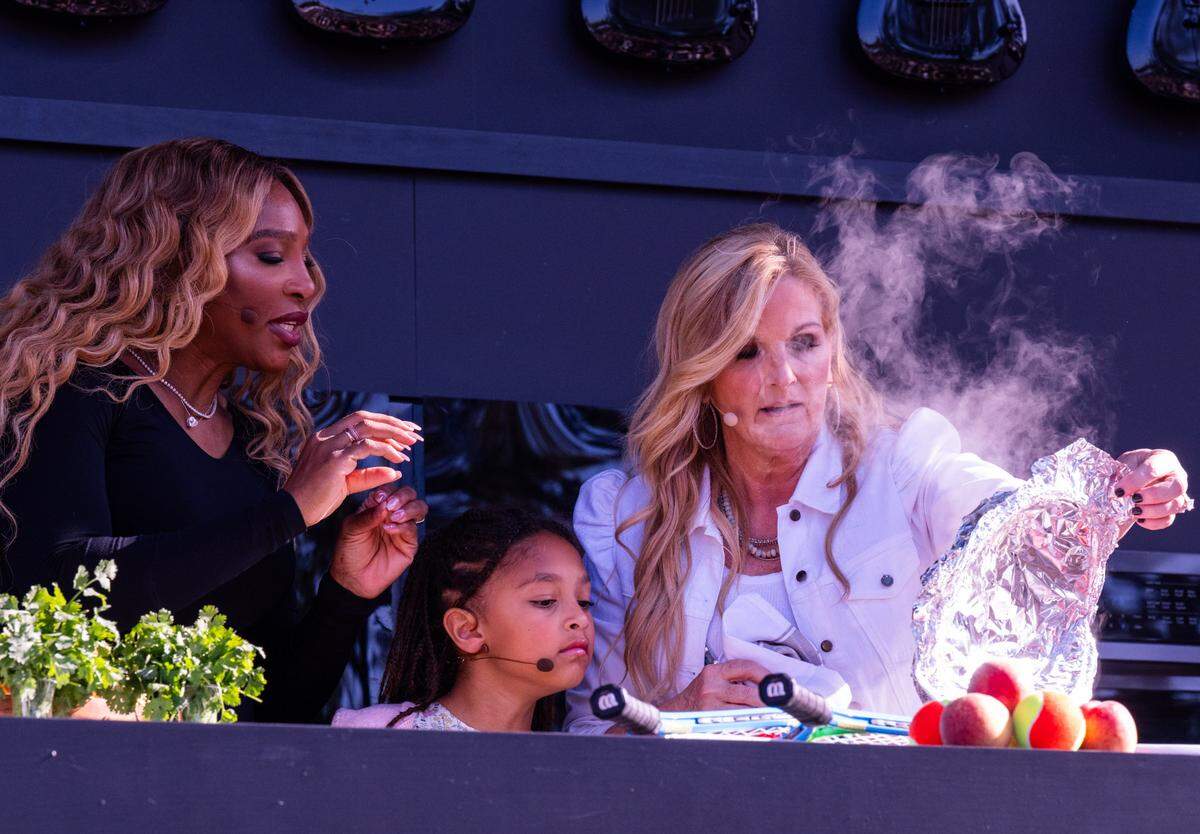 Tennis star Serena Williams, left, her daughter Olympia, and county music star Trisha Yearwood reveal a dish during cooking demonstration at the BottleRock music festival in Napa on Friday, May 23, 2025. 