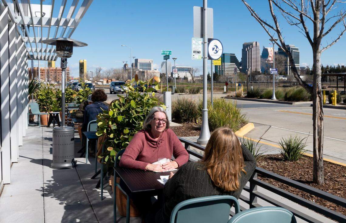 Karen Cecchi and Rachel Dutch sit outside Franquette, a new French-inspired wine bar and cafe in the developing neighborhood of West Sacramento’s Bridge District, on Wednesday.