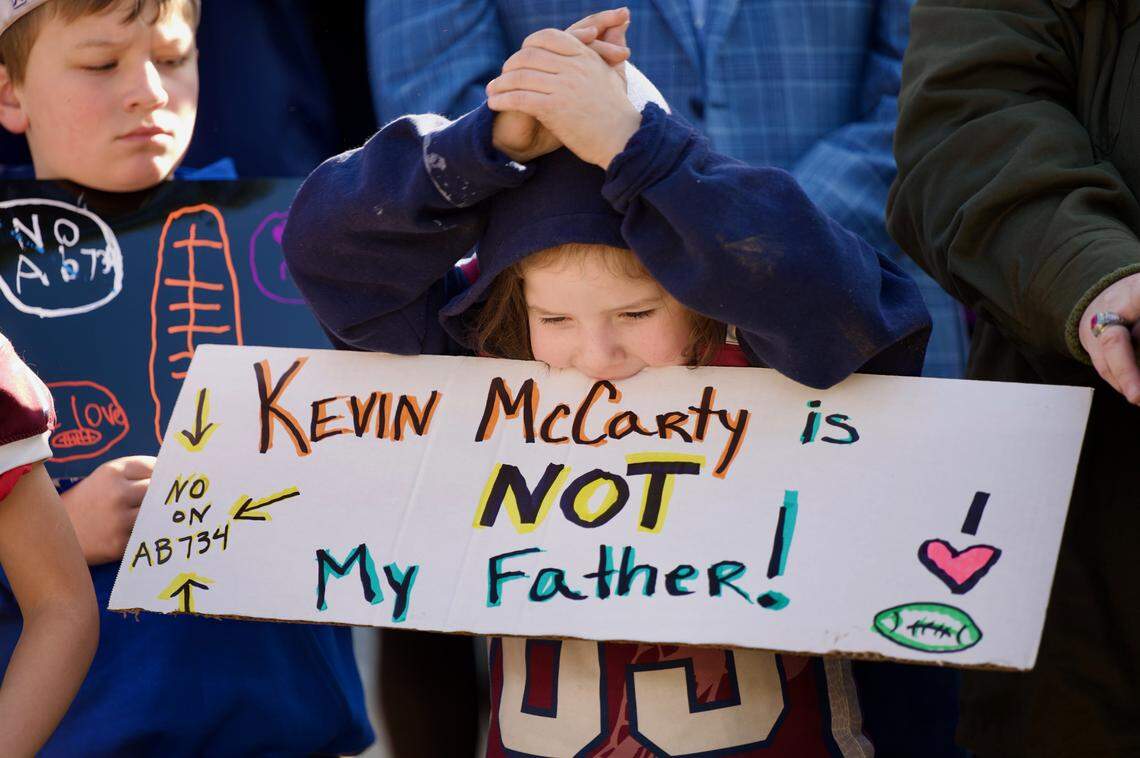 Bruce Bertram, 7, who plays for the Rattlers, a feeder program for Union Mine High School, claps for speakers at a rally at the state Capitol on Wednesday against a bill by Assemblyman Kevin McCarty that would eventually prohibit kids under age 12 from playing tackle football.
